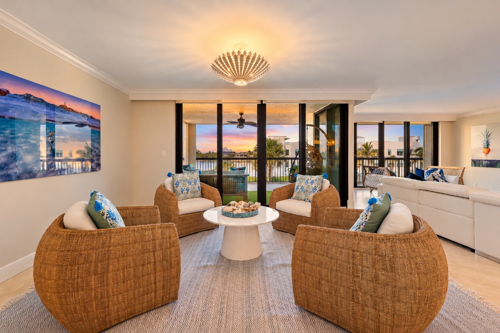 Den and sitting room with wicker chairs and Intracoastal views through sliders