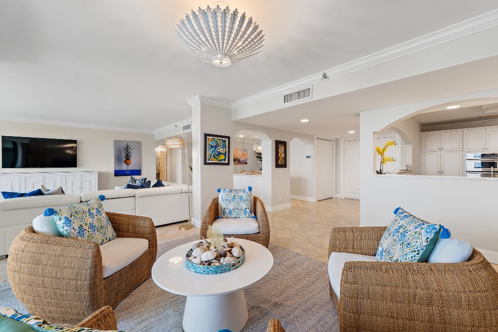 Living and den with chandelier and kitchen arch visible