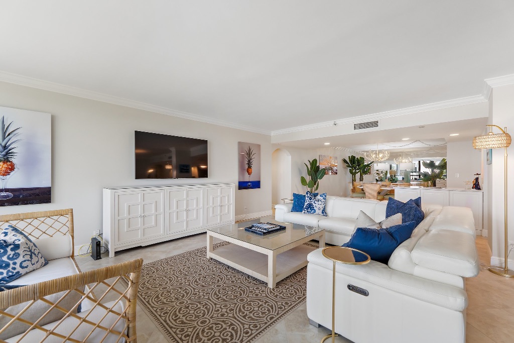 Living room with white sofa, blue pillows and wicker chairs