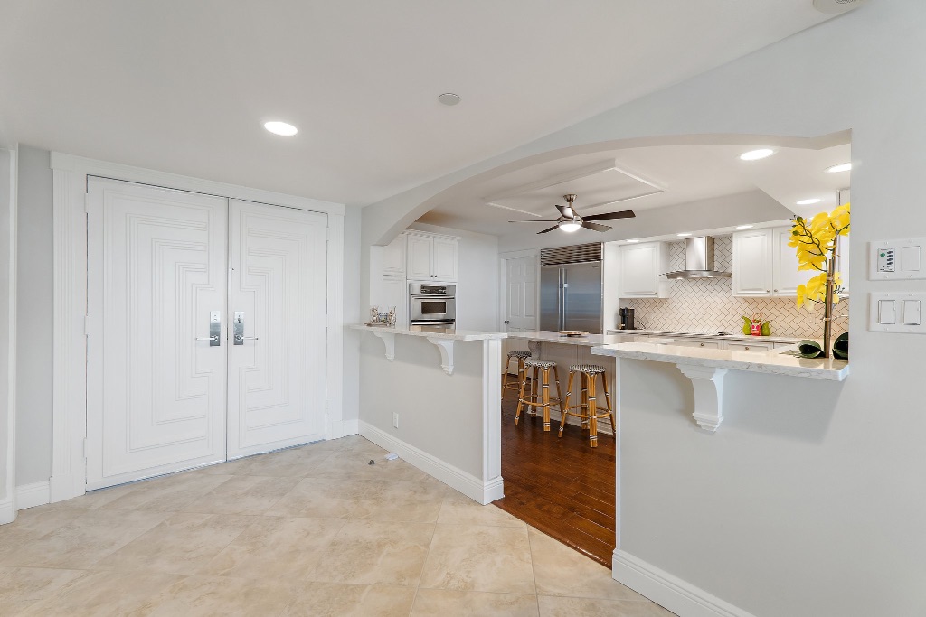 Entry foyer with custom double doors and arched kitchen opening