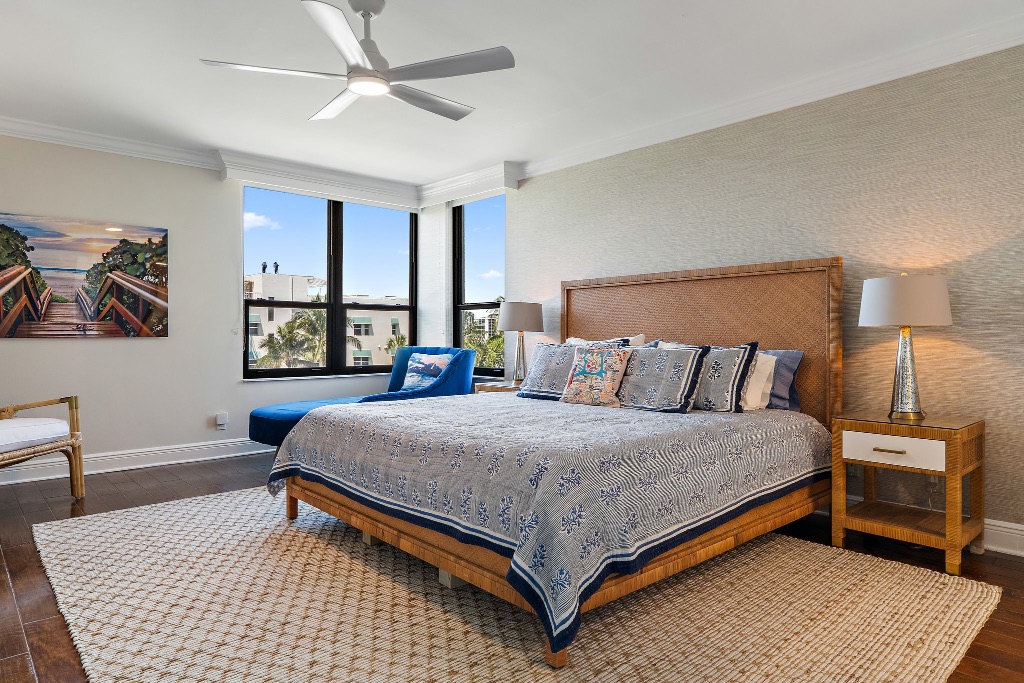 Primary bedroom with rattan headboard, blue bedding and Intracoastal view