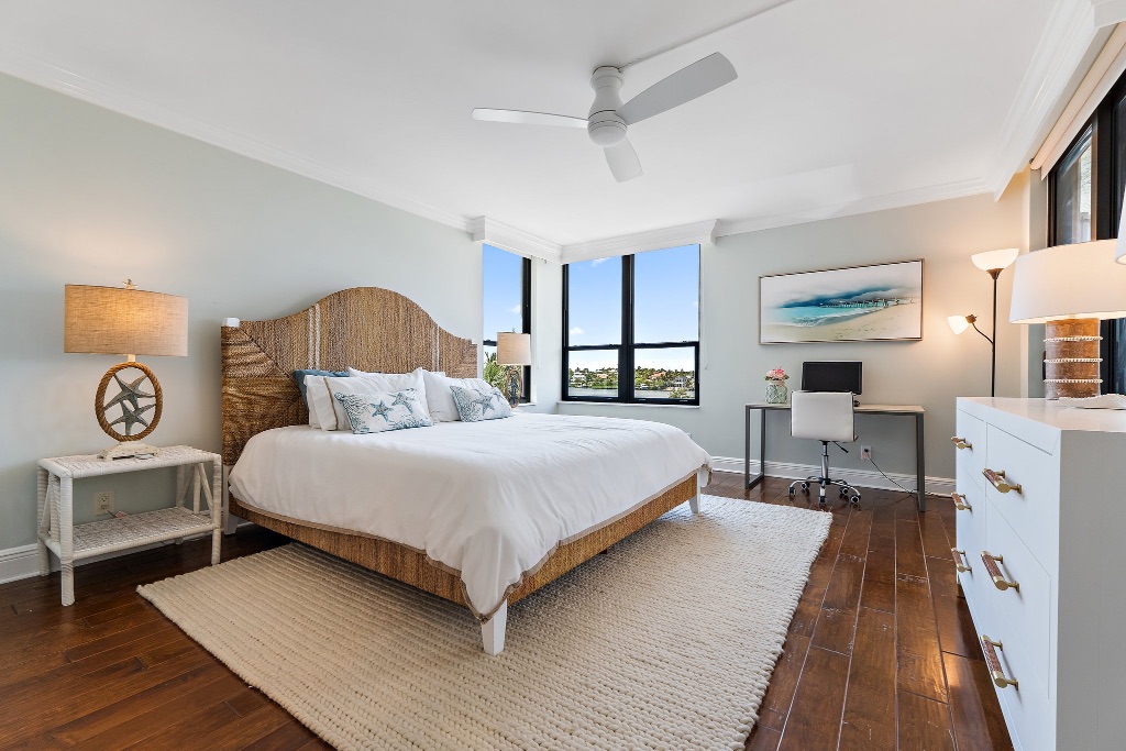 Guest bedroom with rattan headboard, hardwood floors and Intracoastal view window