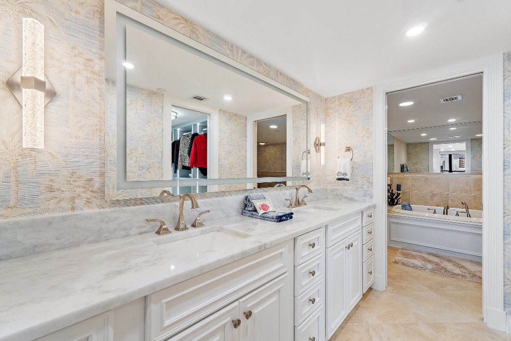 Primary bathroom with double vanity, marble countertop and tropical wallpaper