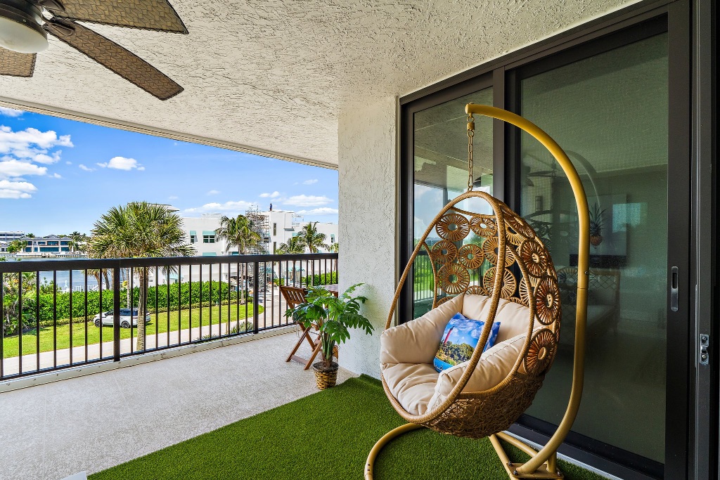 Balcony with wicker egg chair, palm trees and west view
