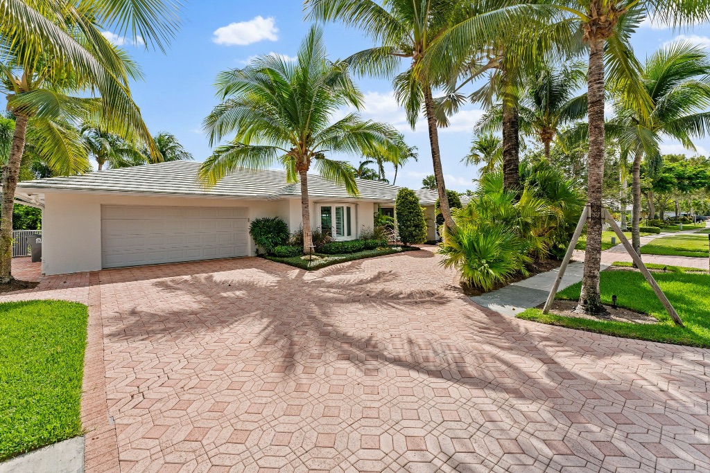 Front exterior — sweeping paver driveway, palm trees, 18150 Perigon Way