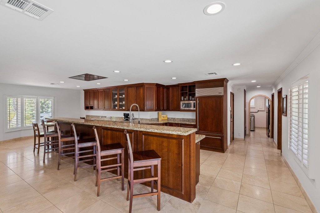 Kitchen bar seating and arched hallway leading to bedroom wing