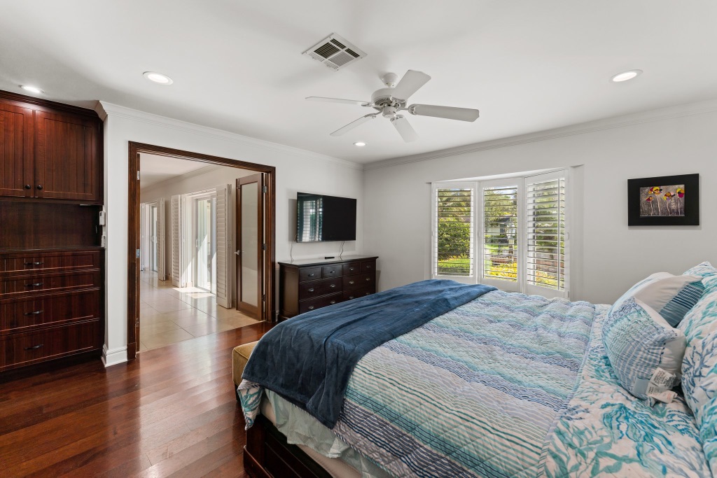 Primary suite — bay window, custom dresser and wall-mounted TV