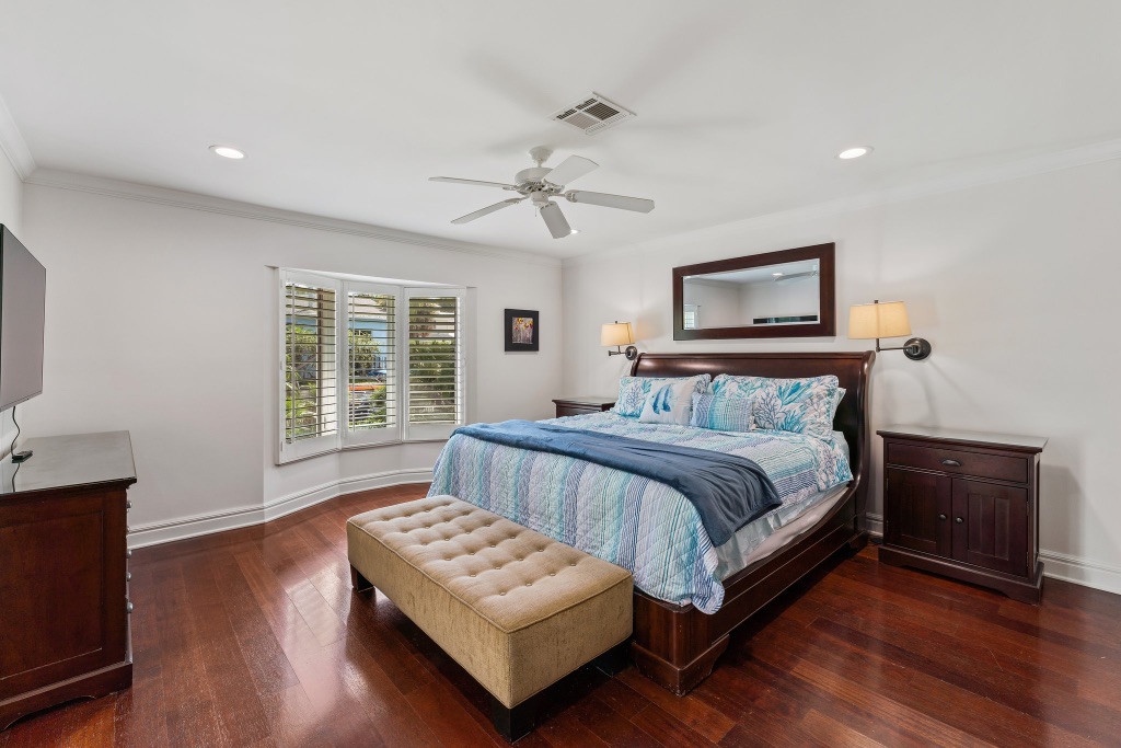 Spacious primary suite with king bed and plantation shutters
