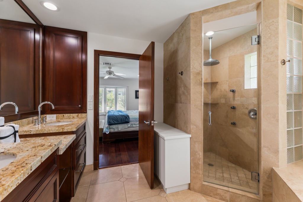 Primary bath — oversized walk-in glass shower with travertine tile