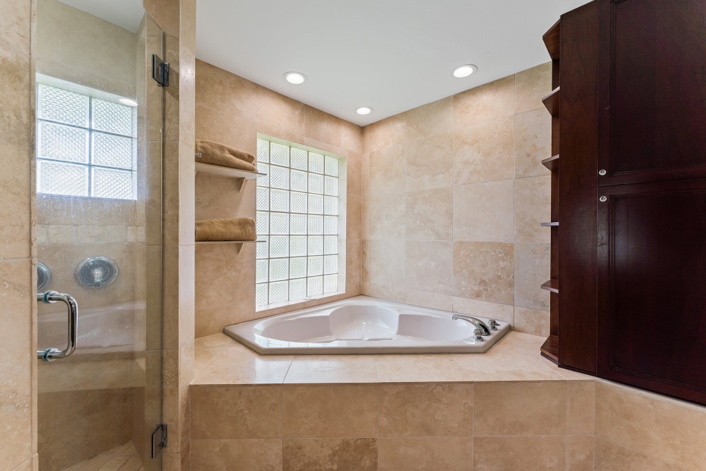 Primary bath — corner soaking tub with glass block window
