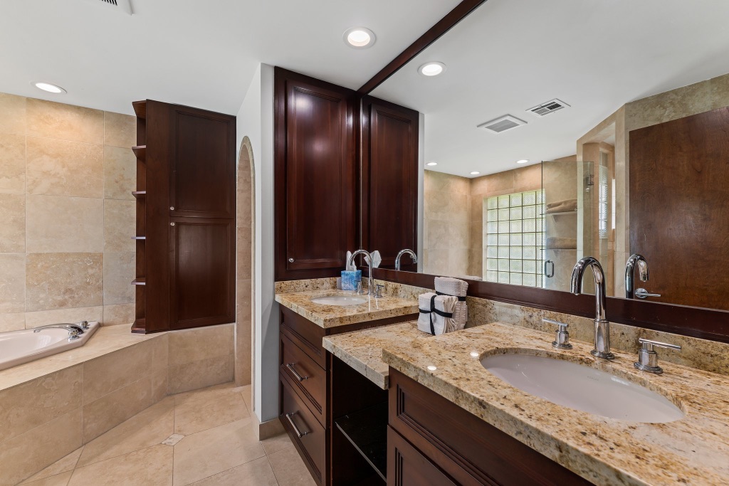 Primary bath — dual-sink vanity with granite tops and custom cabinetry
