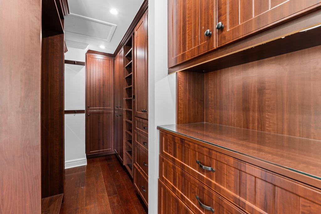 Primary suite — expansive walk-in closet with custom built-in system