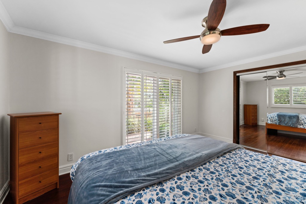 Third bedroom — hardwood floors, plantation shutters and tropical views