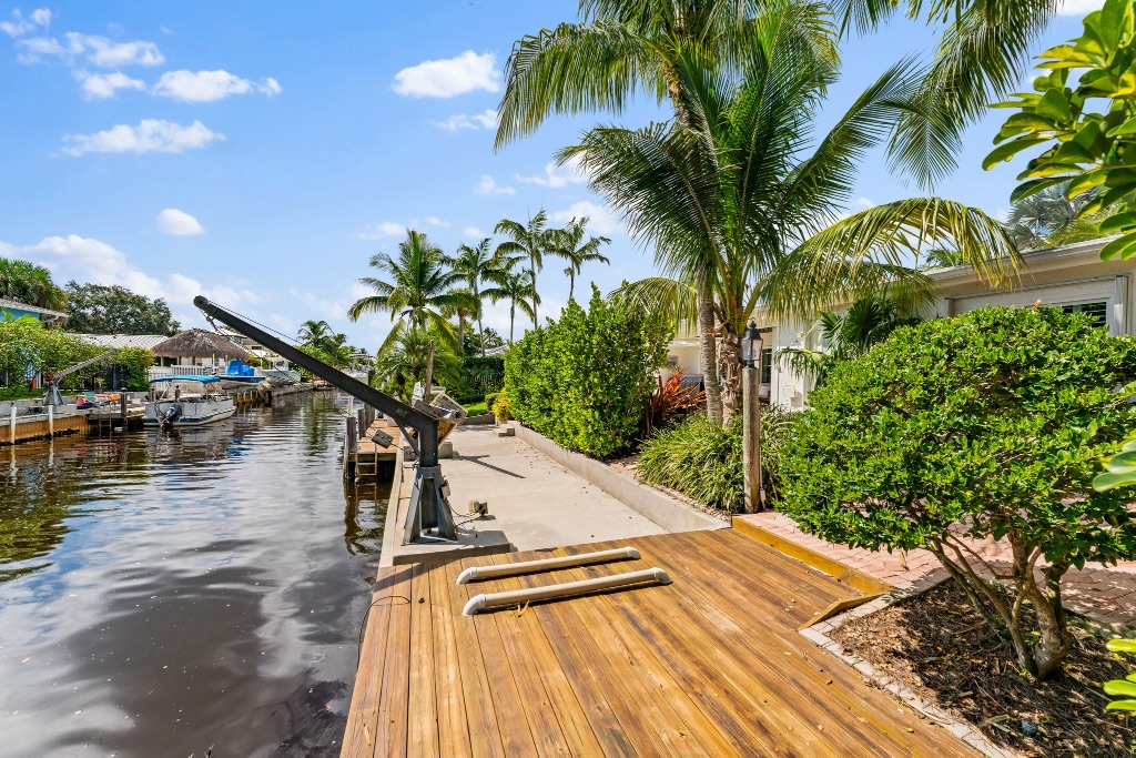 Private dock walkway with teak decking, davit cranes and canal views