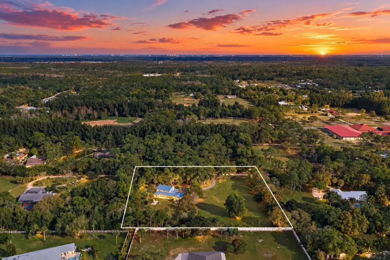 17375 Thunder Road — sunset aerial with property boundary and equestrian pastures