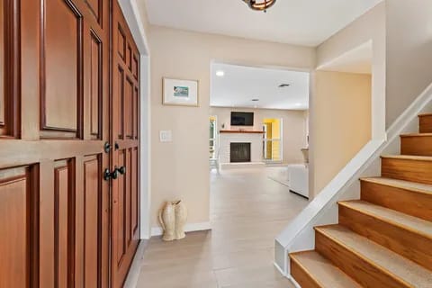 17375 Thunder Road — renovated foyer with wood staircase and living room fireplace