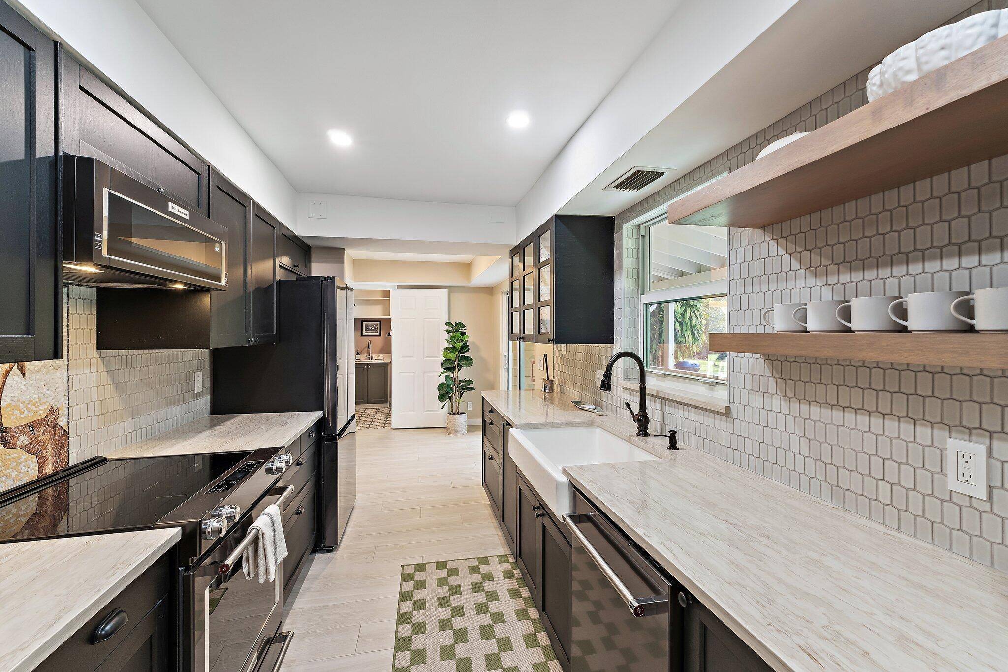 17375 Thunder Road Jupiter FL — renovated kitchen with black cabinetry and farmhouse sink