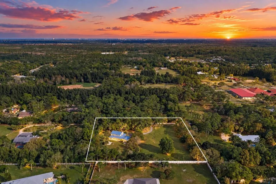 17375 Thunder Road — sunset aerial with full 2.5-acre property boundary outlined