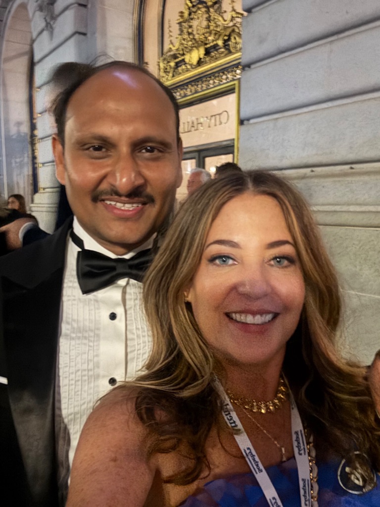 Two Sotheby's International Realty advisors in formal attire take a photo outside San Francisco City Hall on the evening of the 50th anniversary gala